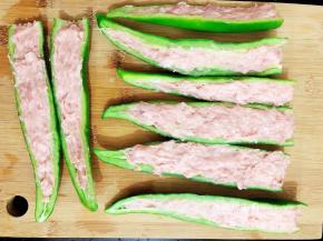 将适量的肉末酿入尖椒中，依次把所有的尖辣都酿好