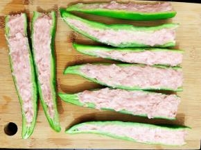 将适量的肉末酿入尖椒中，依次把所有的尖辣都酿好