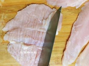 将鸡胸肉展开在砧板上面，用刀背或是擀面杖拍松，拍松的目的是让鸡肉的口感更好，更易入味