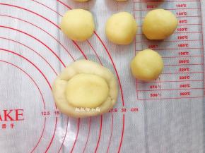 取一份面团压扁后包入椰蓉馅，用虎口位置将面包口，捏紧收口，其余的也依次包好