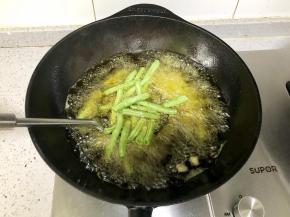 倒入四季豆，炸到四季豆变软，表面起虎皮后捞出备用；