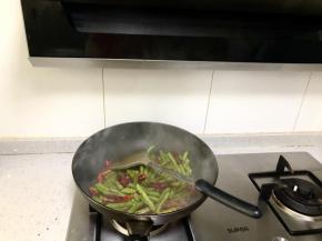 全部炒香后倒入四季豆，加入适量的盐和鸡精，大火翻炒均匀即可起锅。看着油烟嗖嗖的被吸进抽油烟机里，油烟被拦截在脸部以下，不用担心油烟伤害我的皮肤而加速衰老啦。