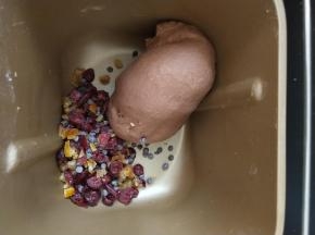 4、揉到能拉出比较薄的膜后加入橙皮，蔓越莓，巧克力豆揉匀。