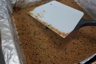 我的消化饼干有芝麻～消化饼干加入融化的黄油搅拌均匀，后借助刮刀刮板，垫了纸的磨具中压平，冰箱冷藏，备用建议垫纸，方便脱模～我的磨具是三能屋诺的8寸方磨具～你可以用八寸的圆磨具，6寸的话蛋糕体就会更高更高一些，其实都OK，开心就好，但不建议比8寸更大的磨具啦，方的比较好切啦～用三能28金盘做的话，请翻倍做