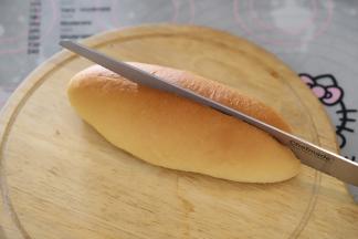 将面包胚从中间切开，但不要切断。