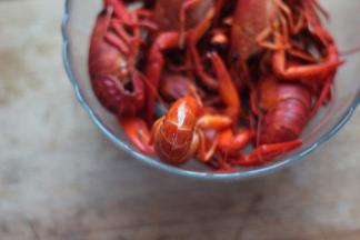 4 龙虾入开水中煮熟。小龙虾的尾部用剪刀剪一条缝，以便做时入味。