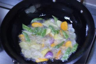 5 锅中入油烧热，加入土豆、豆角、胡萝卜中火炸到五成熟再放洋葱炸，炸到表皮金黄色捞出备用。