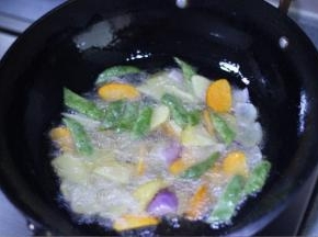 5 锅中入油烧热，加入土豆、豆角、胡萝卜中火炸到五成熟再放洋葱炸，炸到表皮金黄色捞出备用。