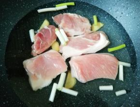 五花肉洗干净切成大块，凉水入锅，加入一勺料酒、少许葱姜焯水。
