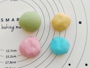 面团分成4份，分别加入不同颜色的果蔬粉揉成团。