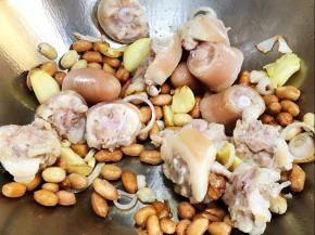 加入花生米和猪尾巴炒香