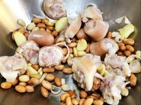加入花生米和猪尾巴炒香