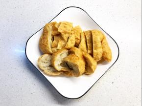 面筋用热水泡洗几次，目的洗去多余的油份，切薄块备用