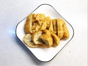 面筋用热水泡洗几次，目的洗去多余的油份，切薄块备用