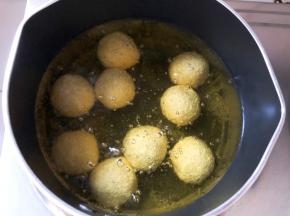 锅中倒入食用油，多一点，最好能末过麻球，油温烧至5层热，放入麻球小火炸