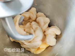 先用厨师机低速搅拌成团，再高速搅打7分钟后放入软化的黄油，继续搅打。