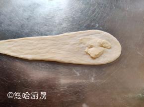 面团从中间上下擀开，在粗的一头抹上一点软化的有盐黄油。