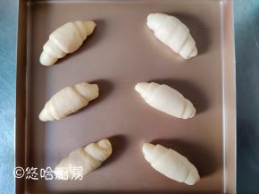 面团从上至下卷起来，成一个小牛角的形状。整形后的面团摆放在烤盘中，放在温暖、湿润的地方进行发酵。没有发酵箱就用烤箱，烤箱不插电放烤盘，烤盘下面放1碗热水。