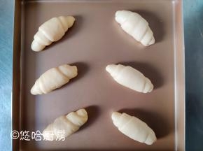 面团从上至下卷起来，成一个小牛角的形状。整形后的面团摆放在烤盘中，放在温暖、湿润的地方进行发酵。没有发酵箱就用烤箱，烤箱不插电放烤盘，烤盘下面放1碗热水。