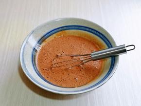 把凉了的可可液倒入蛋黄器具中，手动打蛋器打至均匀。