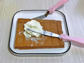 取一片蛋糕片，抹上打发的奶油。