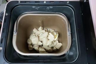 当IMAX程序结束后，取出面团用剪刀剪成小块，同时把软化好的黄油一并放入面包桶内，然后再次设置一个IMIX程序。