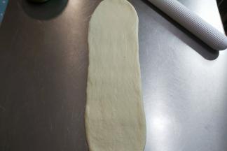 取一个面团简单整理成一个长椭圆形，然后擀长。（有气泡直接拍掉）