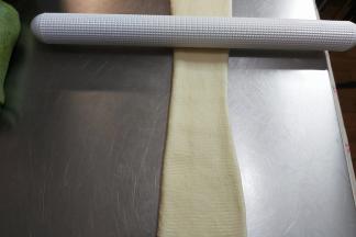 松弛完毕，取一个擀卷的面团，再次轻轻的擀长。