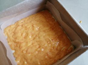 把1/2的蛋糕糊倒入法焙客18CM加高正方形不粘蛋糕模里（烤盘提前铺上油纸，并在四周插上纸板），把咸蛋黄流心酱挤在表面