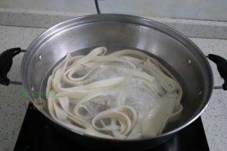 煮锅倒入适量的水煮沸，放入面条，面条放入锅里的时候，需要拉伸，面条变得更薄更长。第一次煮沸之后加一碗水再次煮沸，面条浮起来，说明煮熟了。