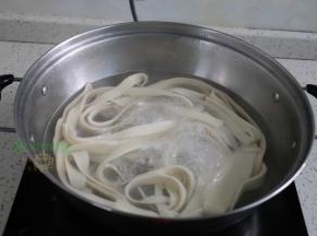 煮锅倒入适量的水煮沸，放入面条，面条放入锅里的时候，需要拉伸，面条变得更薄更长。第一次煮沸之后加一碗水再次煮沸，面条浮起来，说明煮熟了。