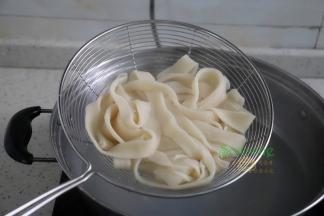 碗里倒入适量的酱油，把煮熟的面条捞出，倒入碗里。