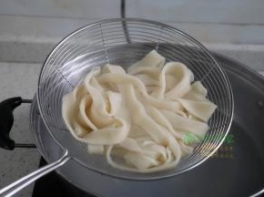 碗里倒入适量的酱油，把煮熟的面条捞出，倒入碗里。