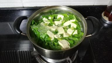 锅里放入适量水煮开，放入豆腐、菜、鸡精