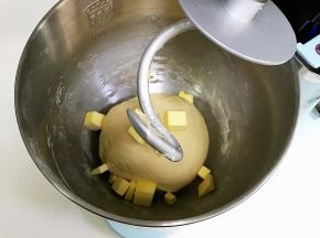 揉至成团，可以拉出粗膜，往搅拌桶内加入黄油。