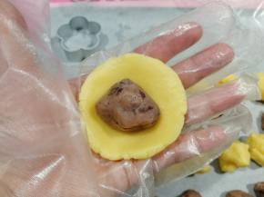 饼皮放手心，用另一手按扁成圆形，放入馅料球。