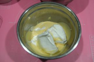 取1/3蛋白霜到蛋黄糊中，左手配合逆时针转盆，右手用蛋抽从色中心切入，从盆底往盆边翻起，打蛋器上的在盆边敲下，重复切拌，翻拌动作，初步混匀。