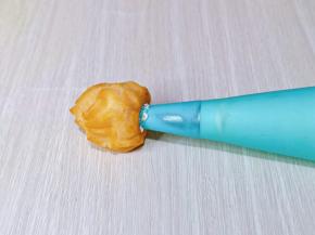 这时泡芙也凉了，用筷子捅个小洞洞，再将裱花嘴插入洞洞里，挤入奶油即可。