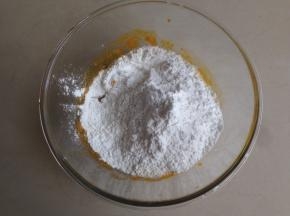 蒸好的南瓜放入碗里，随便压压即可，趁热倒入糖和糯米粉