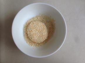 放在白芝麻里，压扁一下，两面都粘满白芝麻