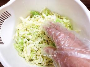 接着戴上一次性水套把包心菜用手抓一抓，把包心菜杀出水分