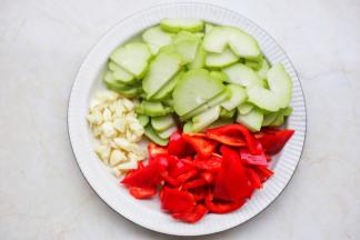 佛手瓜去籽切成薄片，大红椒切滚刀块，大蒜切碎。