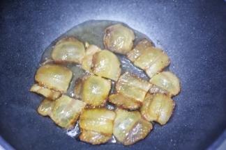 腊肉放入锅中煸炒出油。