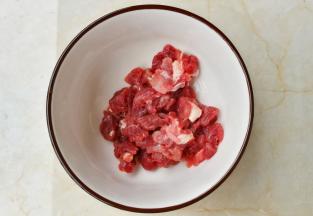 牛肉切丁放入小碗中。