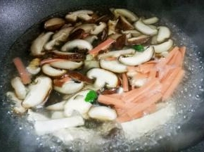 加入香菇木耳火腿煮开。