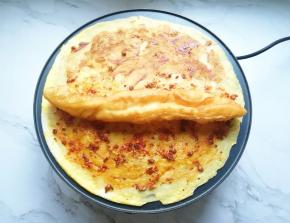 油条从中间撕开，放一半在煎饼上面。