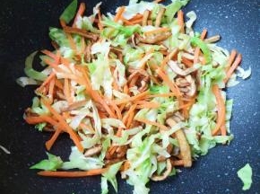 下入包菜和胡萝卜丝翻炒均匀。