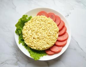 准备好泡面面饼，火腿肠切成片。