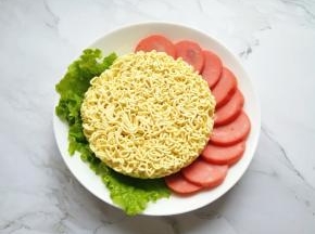准备好泡面面饼，火腿肠切成片。