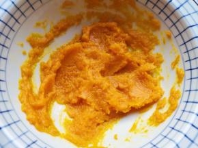 蒸熟的南瓜片从蒸锅里取出，放进大一点的容器里面，用勺子压成南瓜泥。